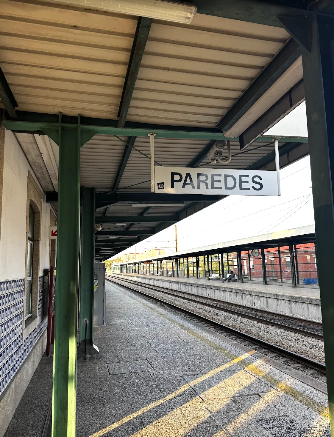 Paredes station sign above the platform, next to the train tracks