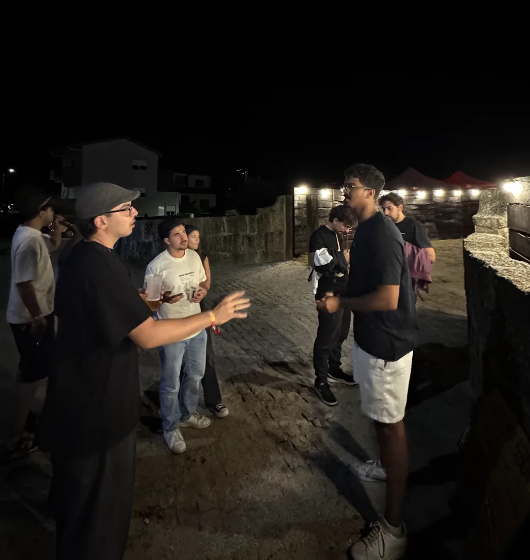Leo talking with a group of young people near the festival entrance at night