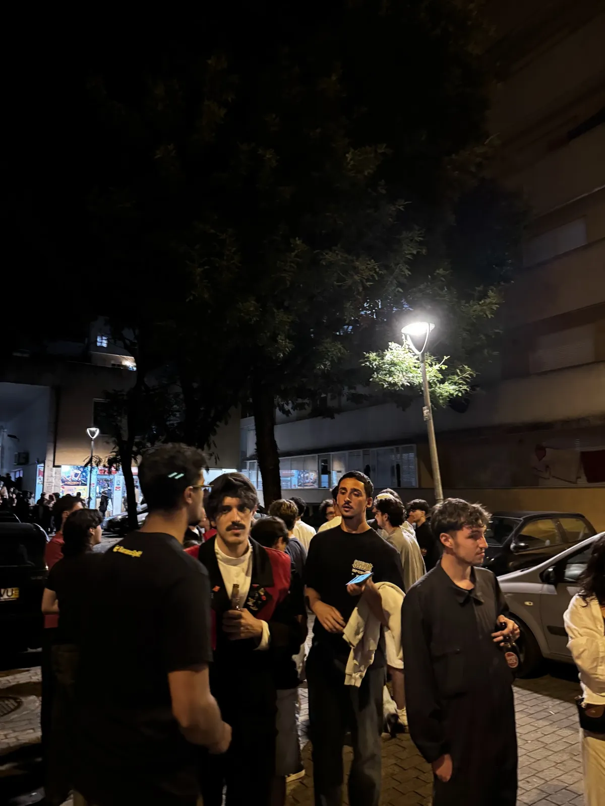 The UM bar street at night, with students walking under the streetlights